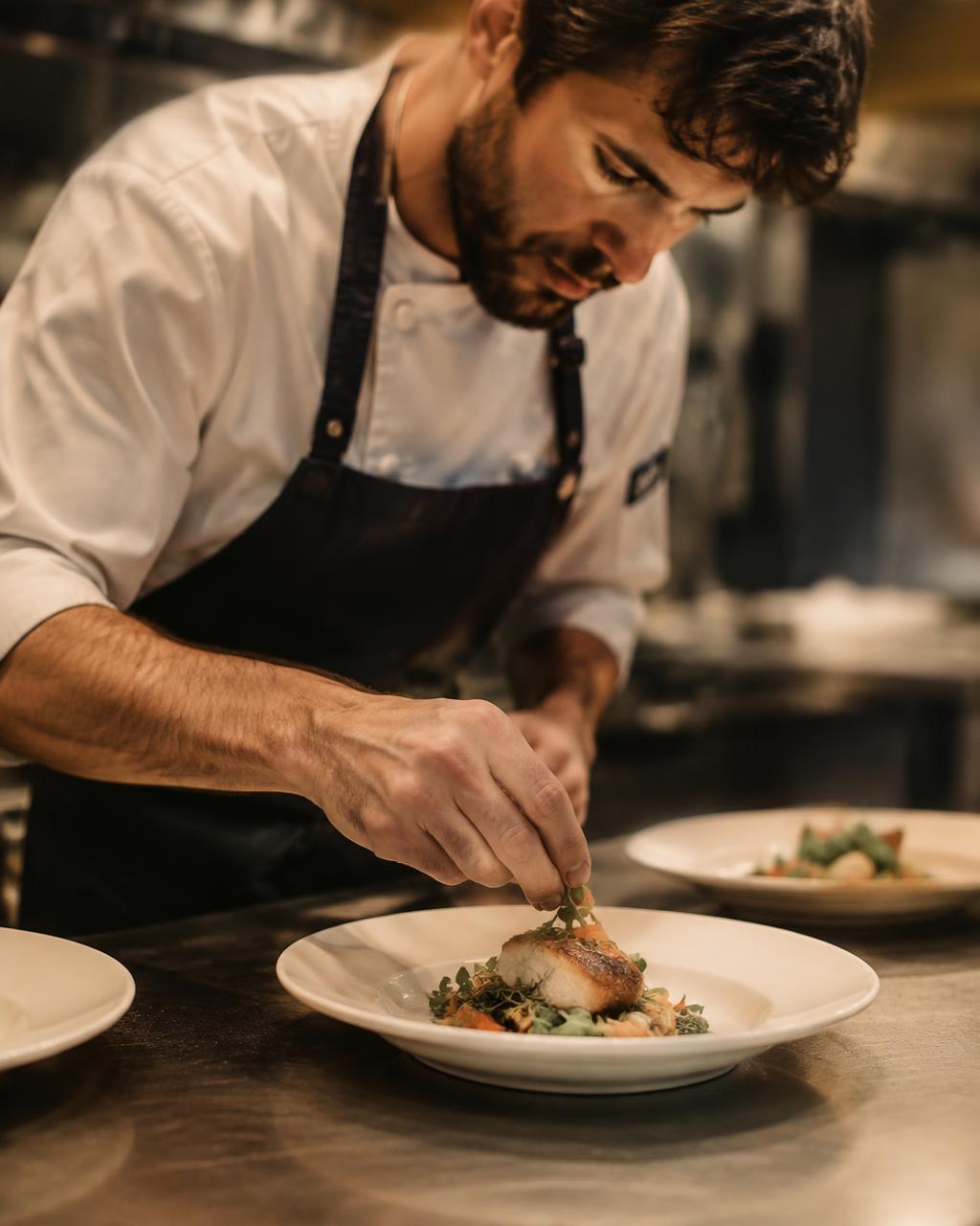 Chef plating a dish in a catering kitchen